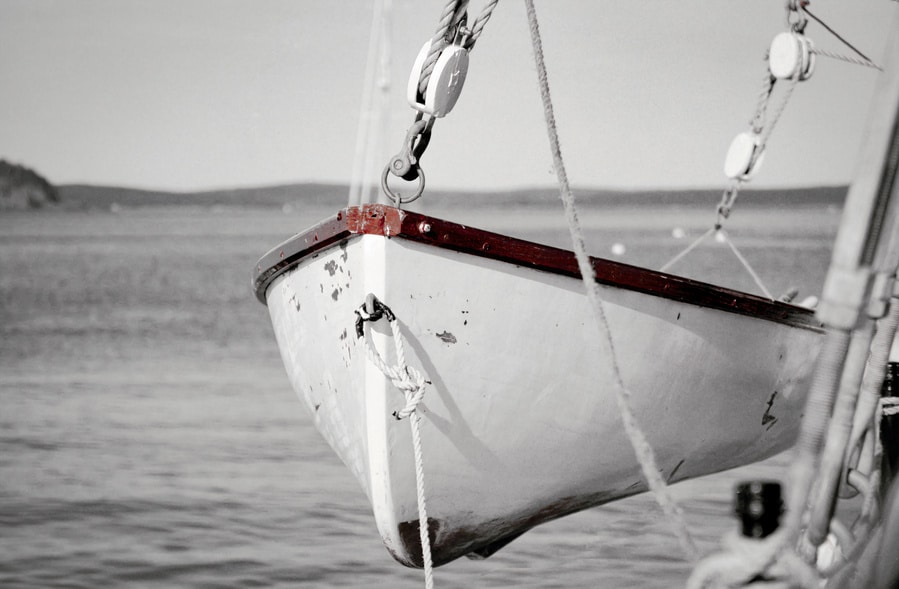 This black and white photograph with a color pop effect captures a life raft from the Margaret Todd, a renowned four-masted schooner based in Bar Harbor, Maine. The image focuses on the red hues of the raft's edges, contrasting vividly against the grayscale background of the serene waters and distant horizon. The Margaret Todd is celebrated for offering scenic tours and sunset cruises around Bar Harbor, allowing passengers to experience the majestic coastal landscapes of Maine. This photograph not only highlights the meticulous details of the life raft but also evokes a sense of preparedness and maritime heritage associated with the schooner.