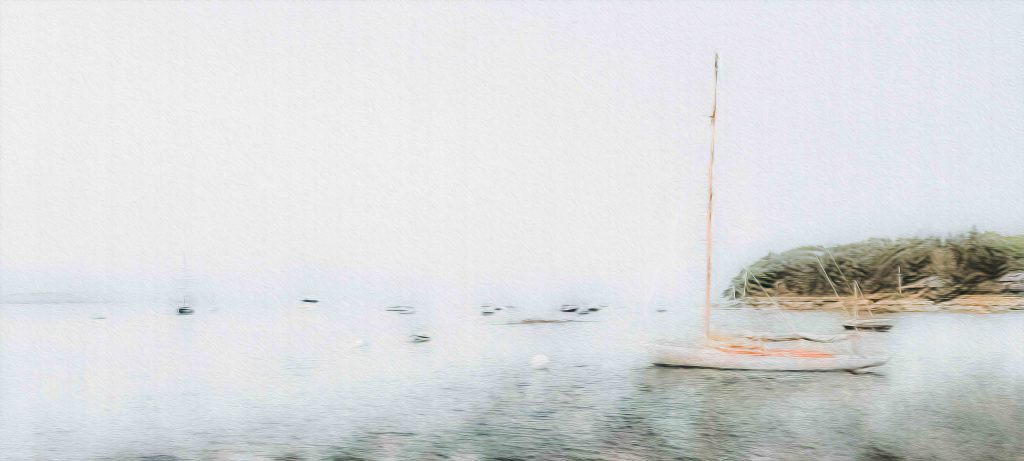 This photograph captures a tranquil scene at the Brooklin Boatyard in Brooklin, Maine. The image, enveloped in a soft fog, features a sailboat moored in calm waters, with the blurred outlines of other boats and the distant shoreline barely visible through the mist. The ethereal atmosphere created by the fog lends the scene a dreamlike quality, emphasizing the quiet solitude of the bay. Brooklin Boatyard, known for its craftsmanship in building and restoring classic wooden yachts, is nestled along the coast of Maine, offering a serene setting for maritime enthusiasts. The delicate pastel tones and soft focus in this photograph evoke a sense of peace and contemplation, perfectly capturing the mood of a foggy morning on the water.