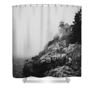 A Fine Art shower curtain featuring the Bass Harbor Lighthouse shrouded in fog, perched on rocky cliffs along the Maine coastline.