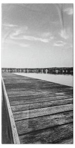 Elevate your bathroom or beach experience with "The Dock" towel, featuring a captivating photograph by Blaine Stoner. This image captures the quiet beauty of a wooden dock extending into the serene waters, evoking a sense of calm and reflection. The monochrome tones bring out the textures of the weathered wood and the stillness of the water, making this towel a perfect blend of art and function. Key Features: Premium Fabric: Made from soft, absorbent material, ideal for use after a swim or bath. Detailed Print: The high-resolution print preserves the intricate details and textures of the dock, providing a visually striking effect. Versatile Size: Perfect for use as a beach towel, bath towel, or a unique decorative piece. Easy Maintenance: Machine washable for convenient care and long-lasting durability. Perfect For: Tranquil Moments: Add a touch of serene beauty to your daily routine with this artistically captured towel. Gifting: An excellent gift for those who appreciate coastal landscapes, minimalistic photography, and fine art.