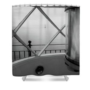 ransform your bathroom into a maritime retreat with the "View from the Lighthouse" Shower Curtain. This evocative photograph by Blaine Stoner captures the tranquil scene from within a lighthouse, looking out onto a solitary sailboat on the calm waters beyond. The monochrome tones and the intricate details of the lighthouse interior contrast beautifully with the serene seascape, making this shower curtain a perfect choice for any coastal or nautical-themed bathroom. Key Features: High-Quality Fabric: Made from 100% polyester, this shower curtain is durable, water-resistant, and designed to last. Detailed, Fade-Resistant Print: The high-resolution print ensures that the subtle contrasts and fine details of the photograph remain sharp and vibrant over time. Generous Size: Measuring 71" x 74", it provides full coverage for standard showers and bathtubs. Easy Installation: Comes with 12 reinforced hook holes, making it simple to hang with your favorite shower curtain hooks. Machine Washable: Easy to care for, this shower curtain is machine washable, allowing for hassle-free maintenance. Perfect for Any Bathroom: Home Decor: Add a touch of coastal elegance to your bathroom with this uniquely artistic shower curtain. Gifting: This shower curtain makes a thoughtful gift for those who appreciate maritime history, lighthouse photography, and serene seascapes. Bring a piece of the sea into your home with the "View from the Lighthouse" Shower Curtain. Photography by Blaine Stoner.