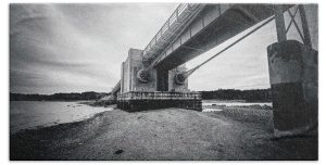 Transform your bathroom with the "Under The Deer Isle Bridge" towel, featuring the striking black and white photography of Blaine Stoner. This image captures the rugged and industrial beauty of the Deer Isle Bridge, with a unique perspective that highlights the intricate structure and the tranquil shore below. The high-contrast tones and detailed textures bring a sense of depth and history to your bathroom decor. Key Features: Premium Quality Fabric: Made from 100% polyester, this towel is soft, absorbent, and perfect for daily use. Vivid, Fade-Resistant Print: The detailed photography is printed with precision, ensuring the unique textures and contrasts remain vibrant over time. Generous Size: Available in multiple sizes to suit your needs, from a hand towel to a large beach towel. Easy Care: Machine washable for hassle-free maintenance, keeping your towel looking fresh and new. Versatile Use: Ideal for use in the bathroom, at the beach, or as a decorative piece. Perfect for Any Bathroom: Home Decor: Add a touch of industrial charm to your bathroom with this beautifully artistic towel. Gifting: This towel makes a thoughtful gift for architecture enthusiasts, photography lovers, and anyone who appreciates unique and functional art. Bring the essence of Maine's coastal bridges into your home with the "Under The Deer Isle Bridge" towel. Photography by Blaine Stoner.