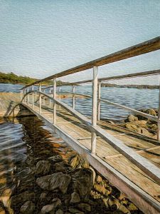 A jigsaw puzzle featuring a gangway extending over rocky shores into the tranquil waters of Blue Hill Bay, with soft lighting and painterly textures.