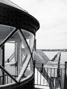 A jigsaw puzzle featuring a view from the top of the Breakwater Lighthouse, showcasing the historic breakwater extending into the bay.