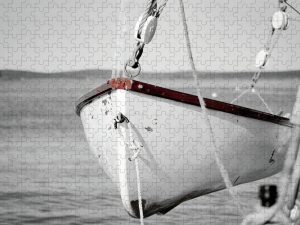 Photograph of a lifeboat from the Margaret Todd in Bar Harbor, Maine, with selective color highlighting the red accents against a black and white background, captured by Blaine Stoner.