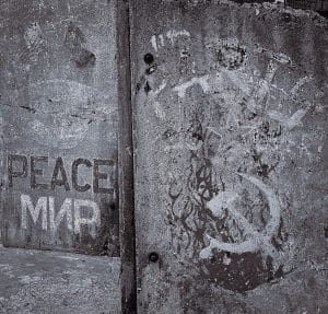 A weathered fragment of the Berlin Wall stands in Portland, Maine, its faded symbols a powerful reminder that even the strongest barriers can be torn down.