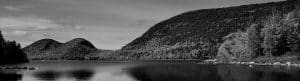 Black-and-white photograph of the Bubbles from Bubble Pond in Acadia National Park, with forested slopes and calm reflective water.